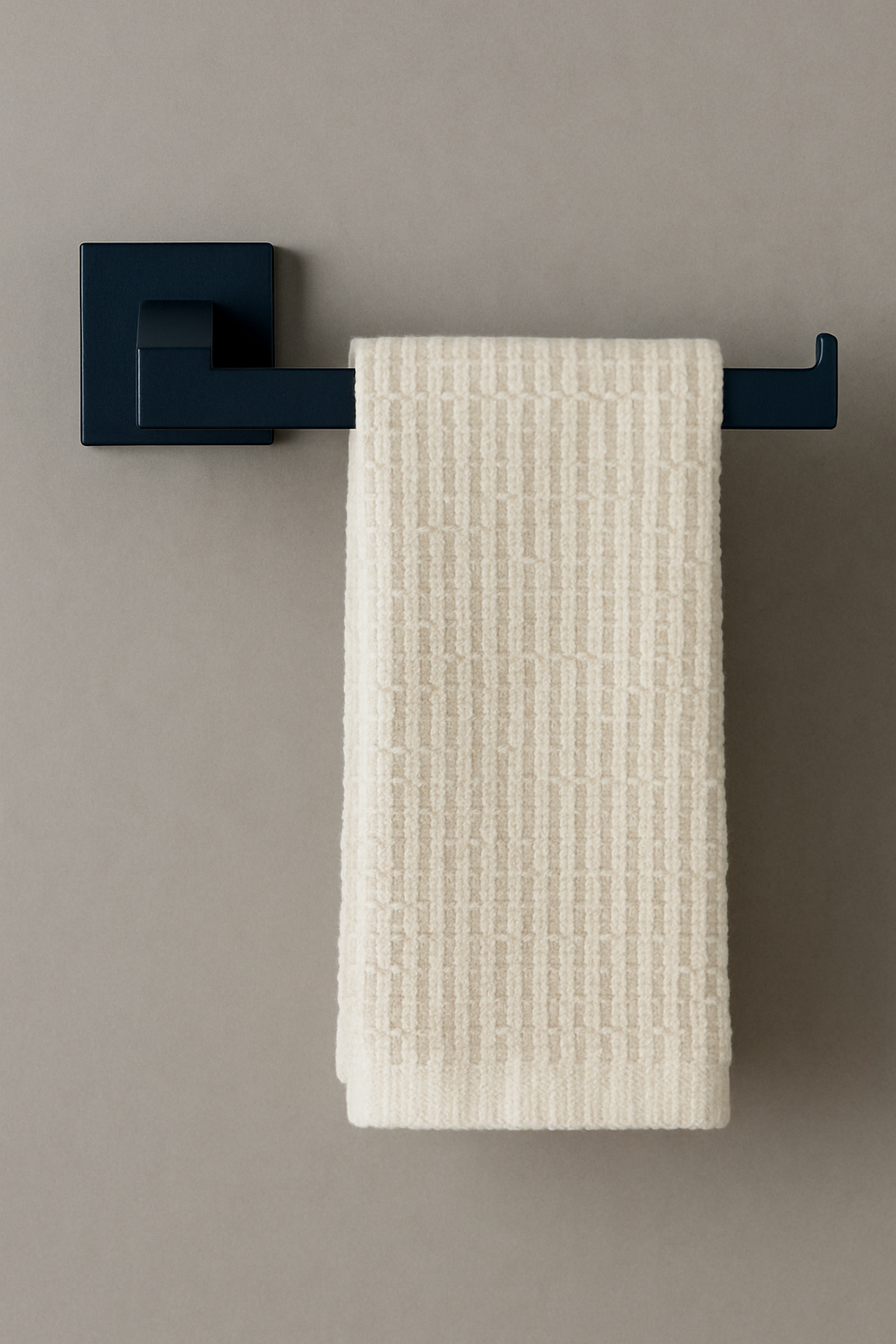 Black towel rack with a beige towel on a beige wall
