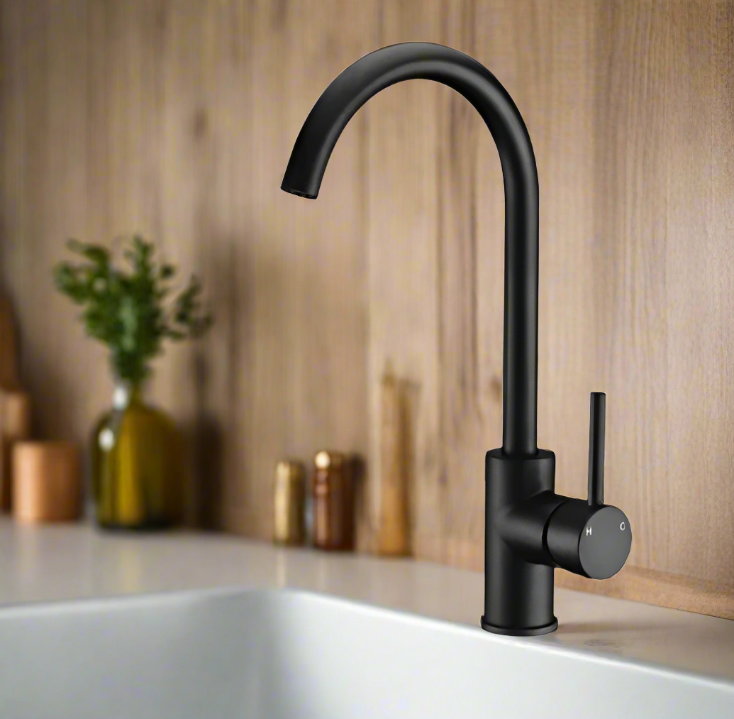 Black kitchen faucet on a countertop with a wooden wall background