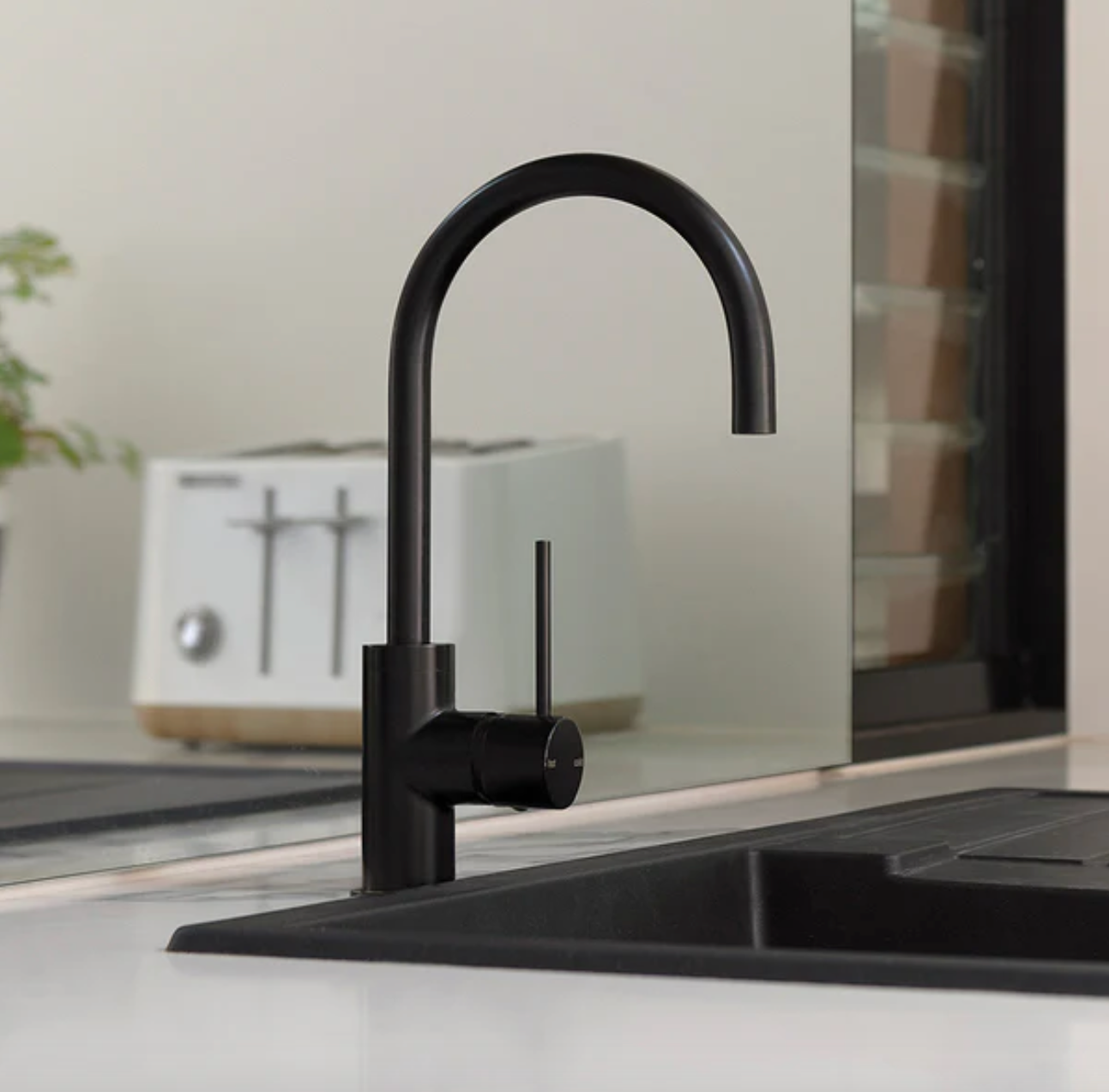 Black kitchen faucet on a modern kitchen counter with a blurred background