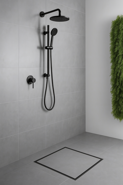 Black shower set mounted on a tiled wall with a plant in the corner.